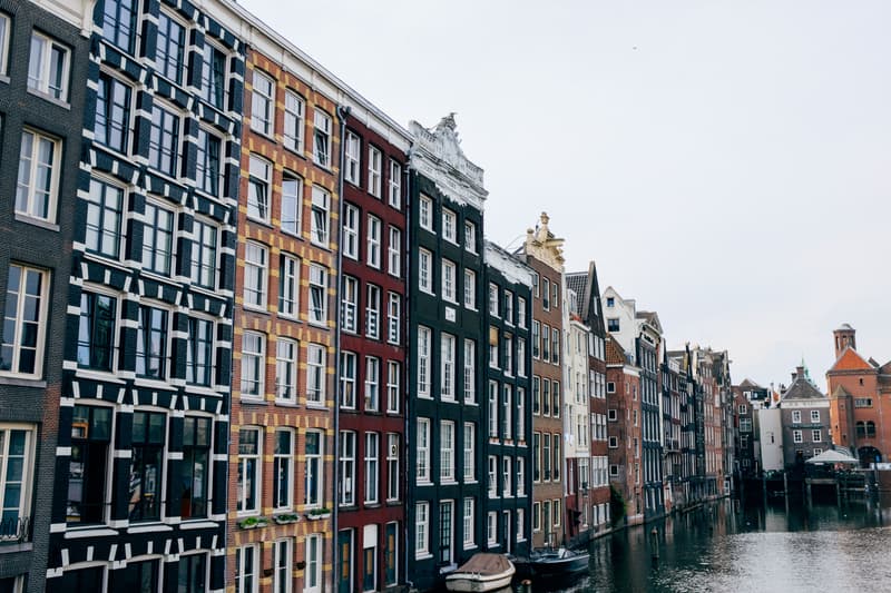 Row of historic gabled canal houses along an Amsterdam canal in daylight