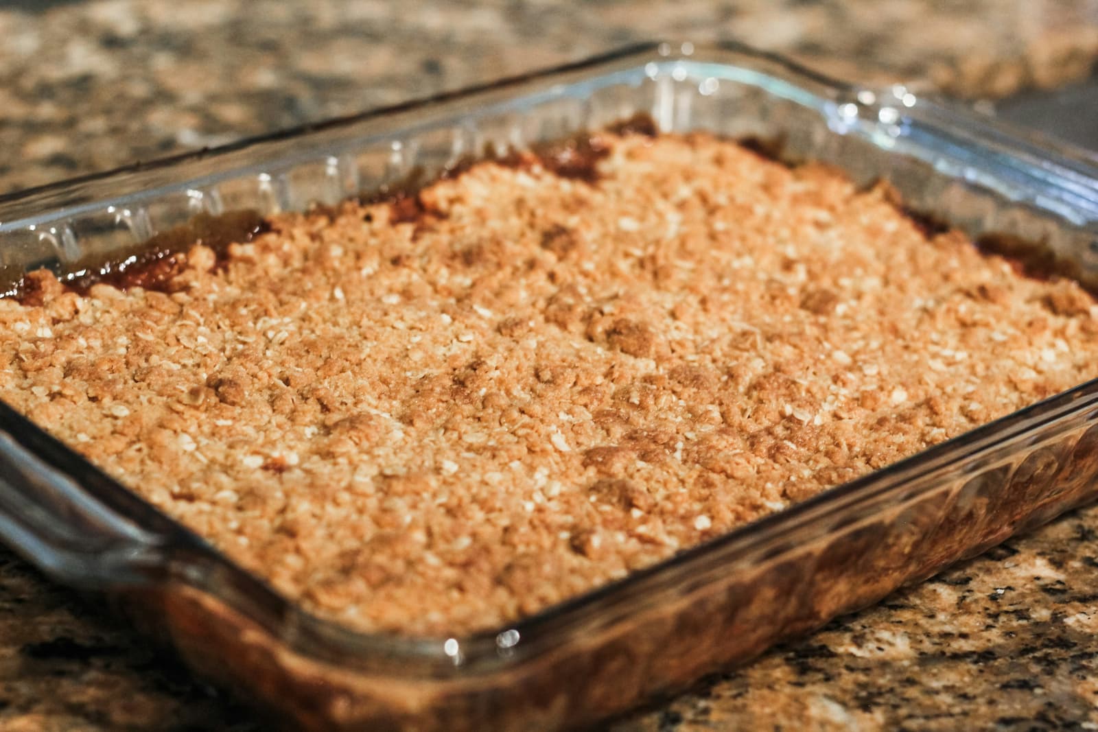 Baked apple crumble with a golden oat topping in a glass dish