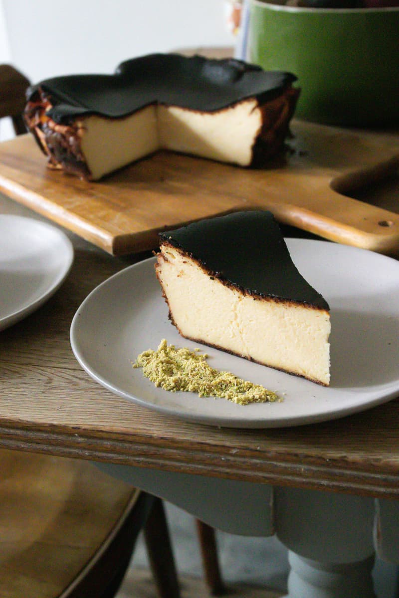 Gesneden Baskische verbrande cheesecake met donkere gekarameliseerde bovenkant op een houten plank