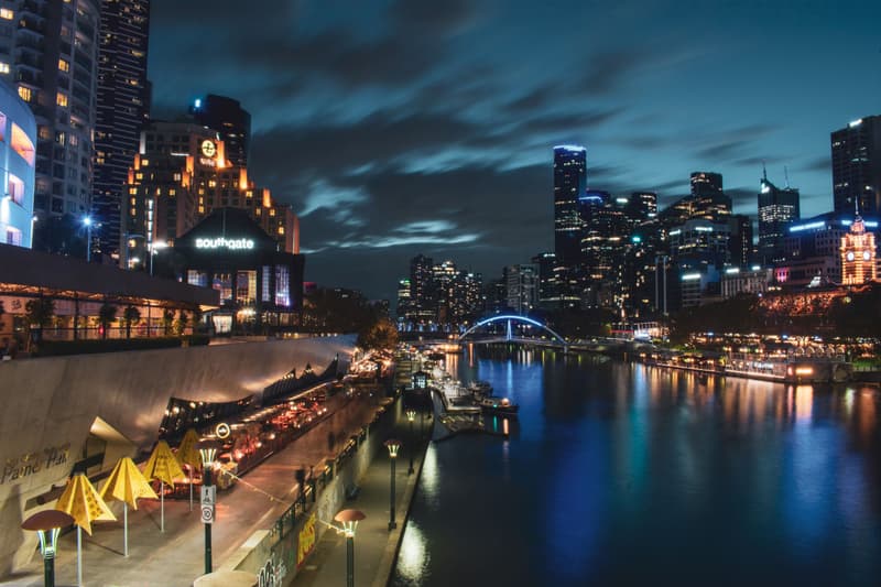 Skyline van Melbourne en restaurants aan Southbank verlicht bij nacht langs de Yarra