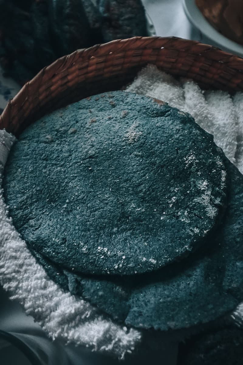 Stack of blue corn tortillas in a woven basket lined with cloth
