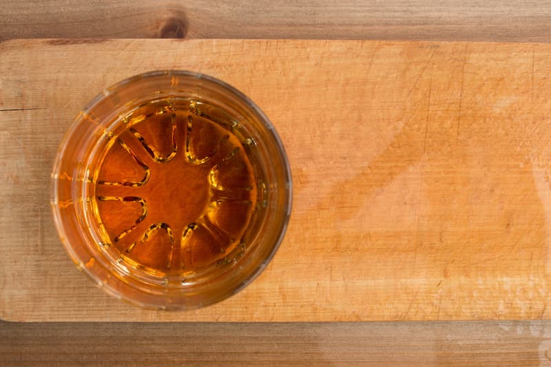 Vue de dessus d'un verre de bourbon ambré sur une planche en bois