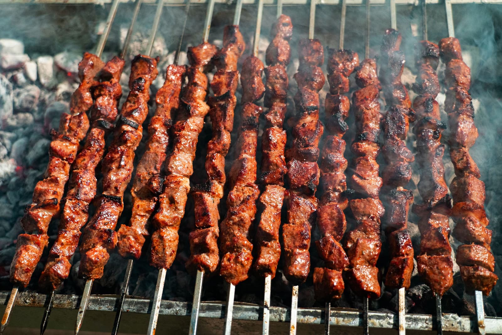 Gegrillte Hackfleischröllchen brutzeln auf einem Holzkohlegrill