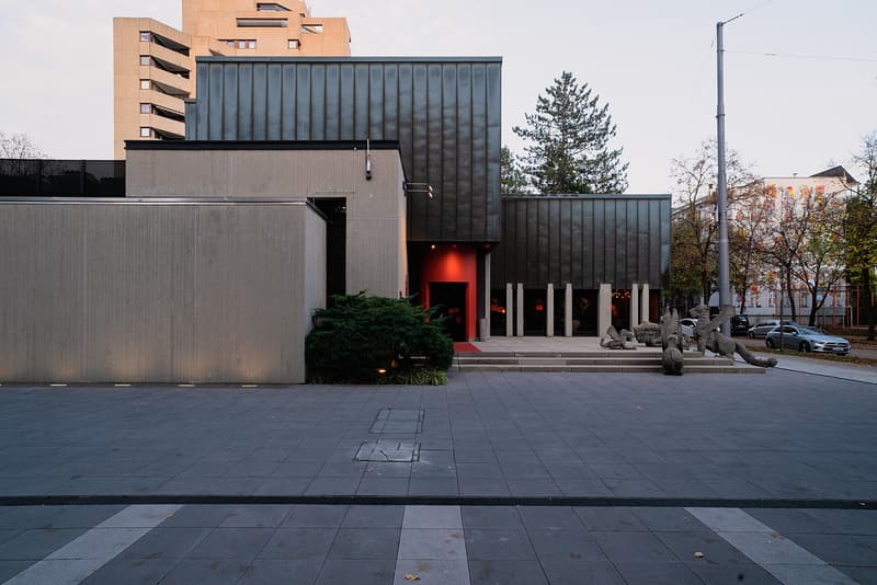 Façade de béton et de métal sombre du restaurant Tantris à Munich, entrée rouge