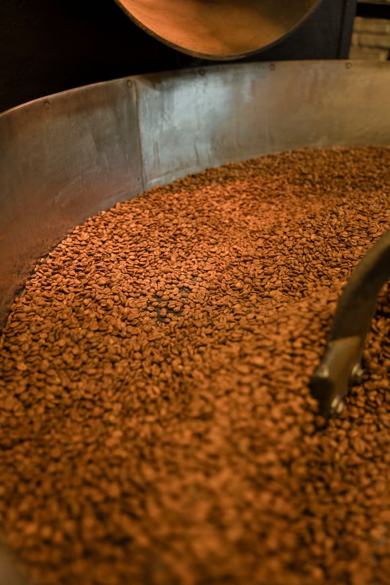 Fresh roasted coffee beans cooling in the drum of an industrial roaster
