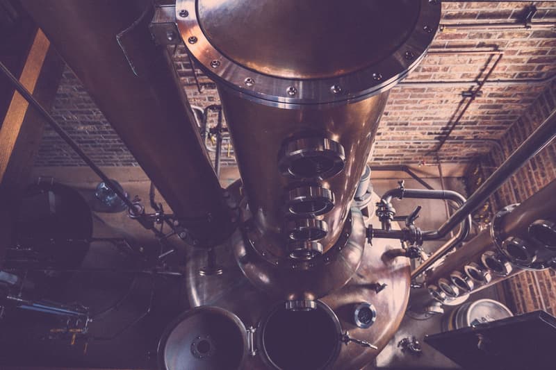 Alambic en cuivre et colonne de distillation dans une distillerie en briques, sans personne