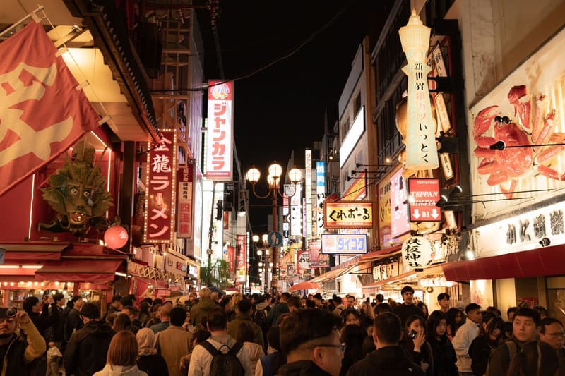 Via Dotonbori a Osaka affollata di notte sotto insegne al neon di ramen, kushikatsu e granchio