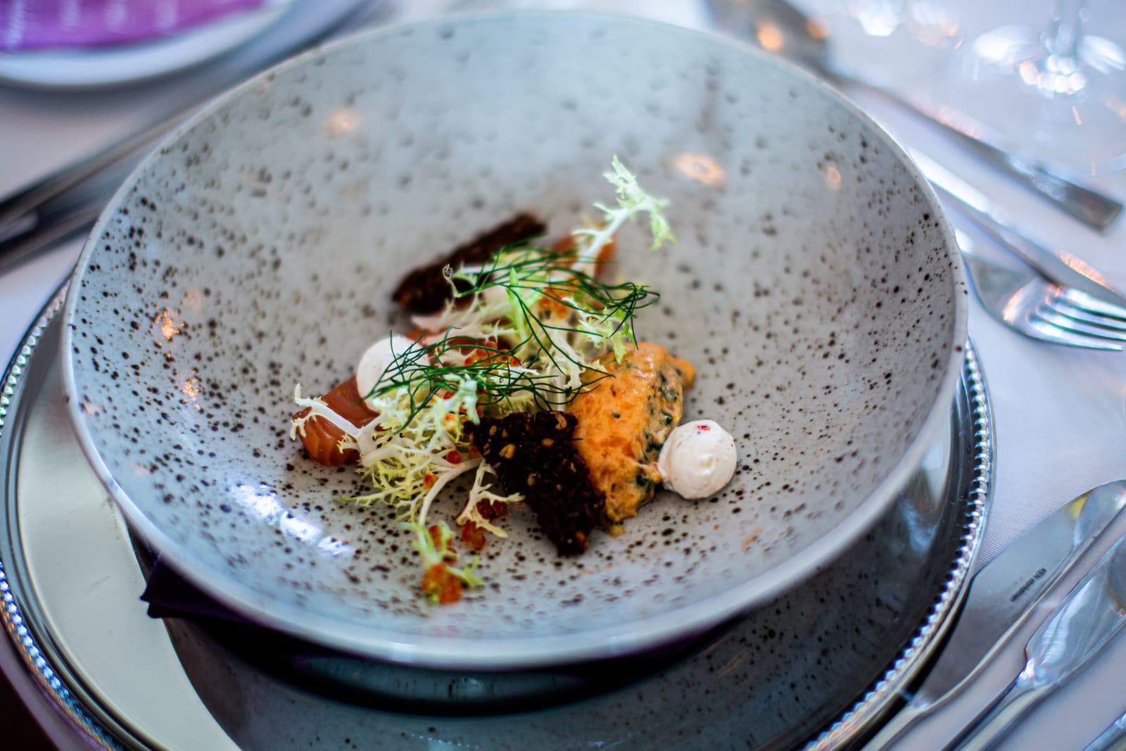 Ein elegant angerichteter Fine-Dining-Teller an einem Restauranttisch in London
