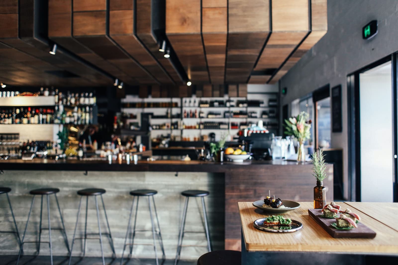 Kleine gerechten op een houten tafel voor een restaurantbar met krukken