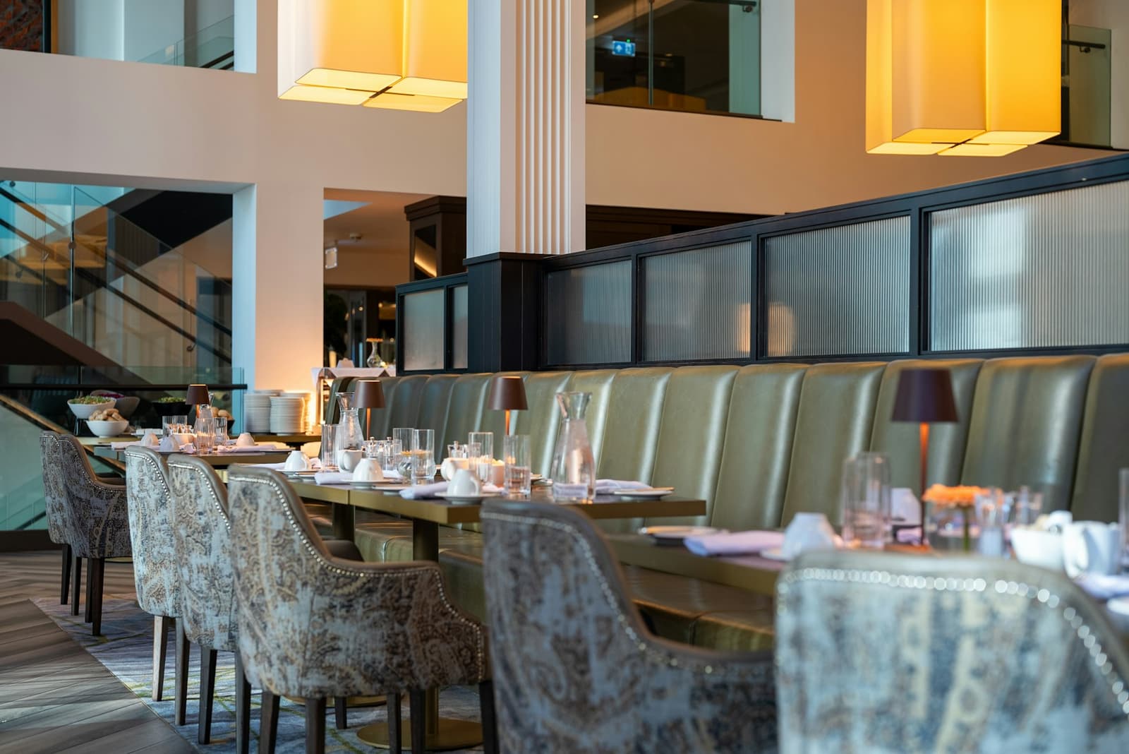 Warm, elegant dining room with plush chairs and set tables