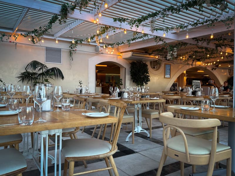 Un elegante comedor de restaurante con copas de vino dispuestas antes del servicio de cena