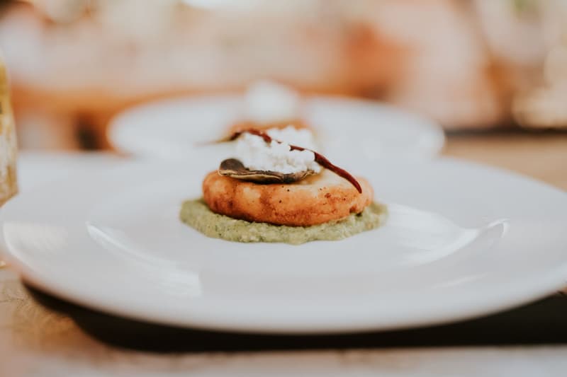 Single-bite tasting course with crisp mushroom and chilli on a white plate