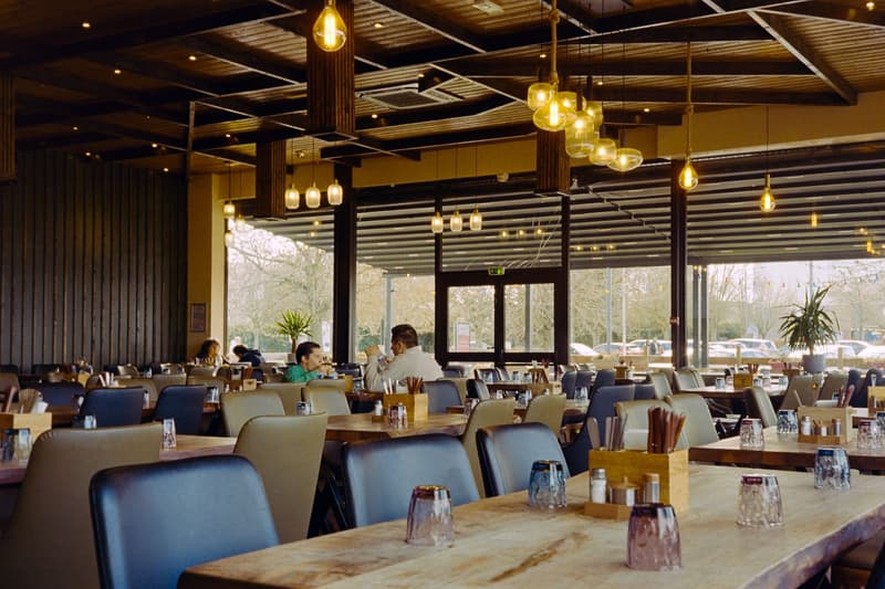 Diners seated at wooden tables inside a warmly lit bistro dining room