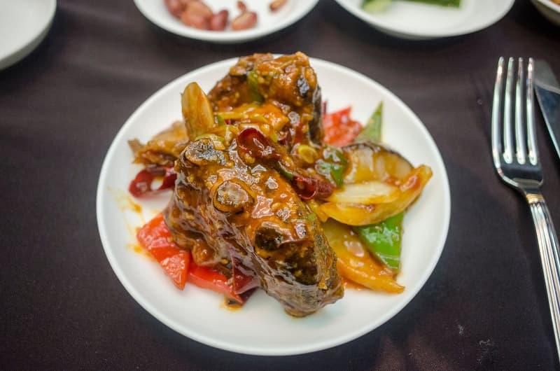 Côte de bœuf braisée et glacée aux poivrons et à l'oignon dans une assiette blanche