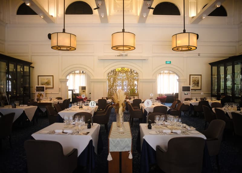 Sala da pranzo coloniale con finestre ad arco, lampade a tamburo e una grata dorata