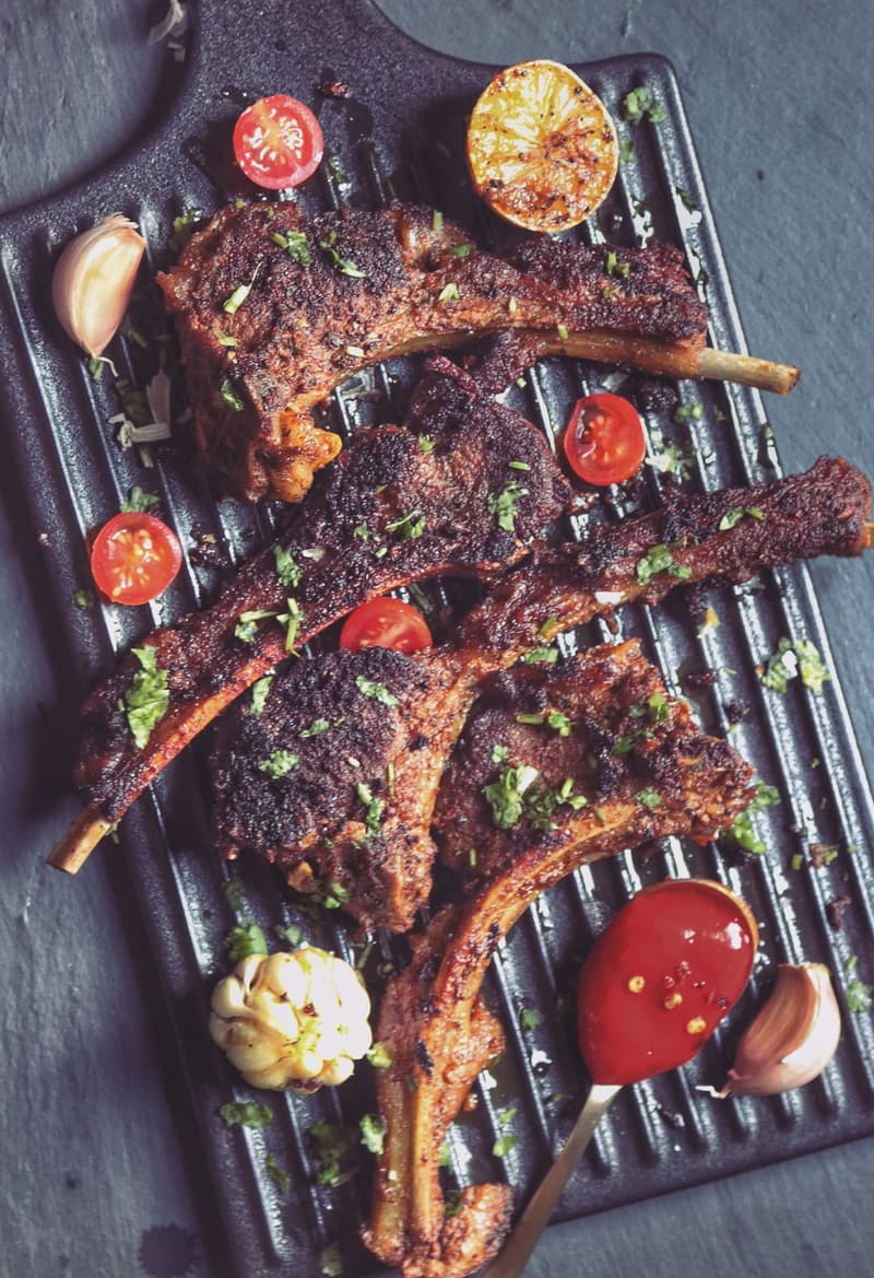 Costolette di agnello grigliate con harissa su una griglia con limone e aglio