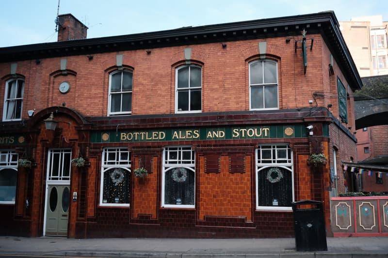 Façade historique en briques rouges d'un pub britannique avec enseigne carrelée