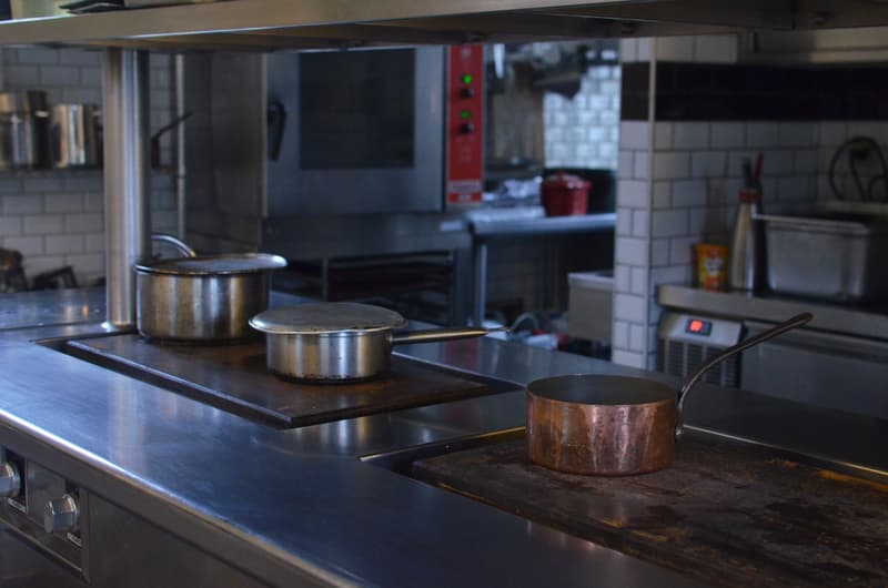 Casseroles en cuivre et en acier sur le piano d'une cuisine professionnelle vide