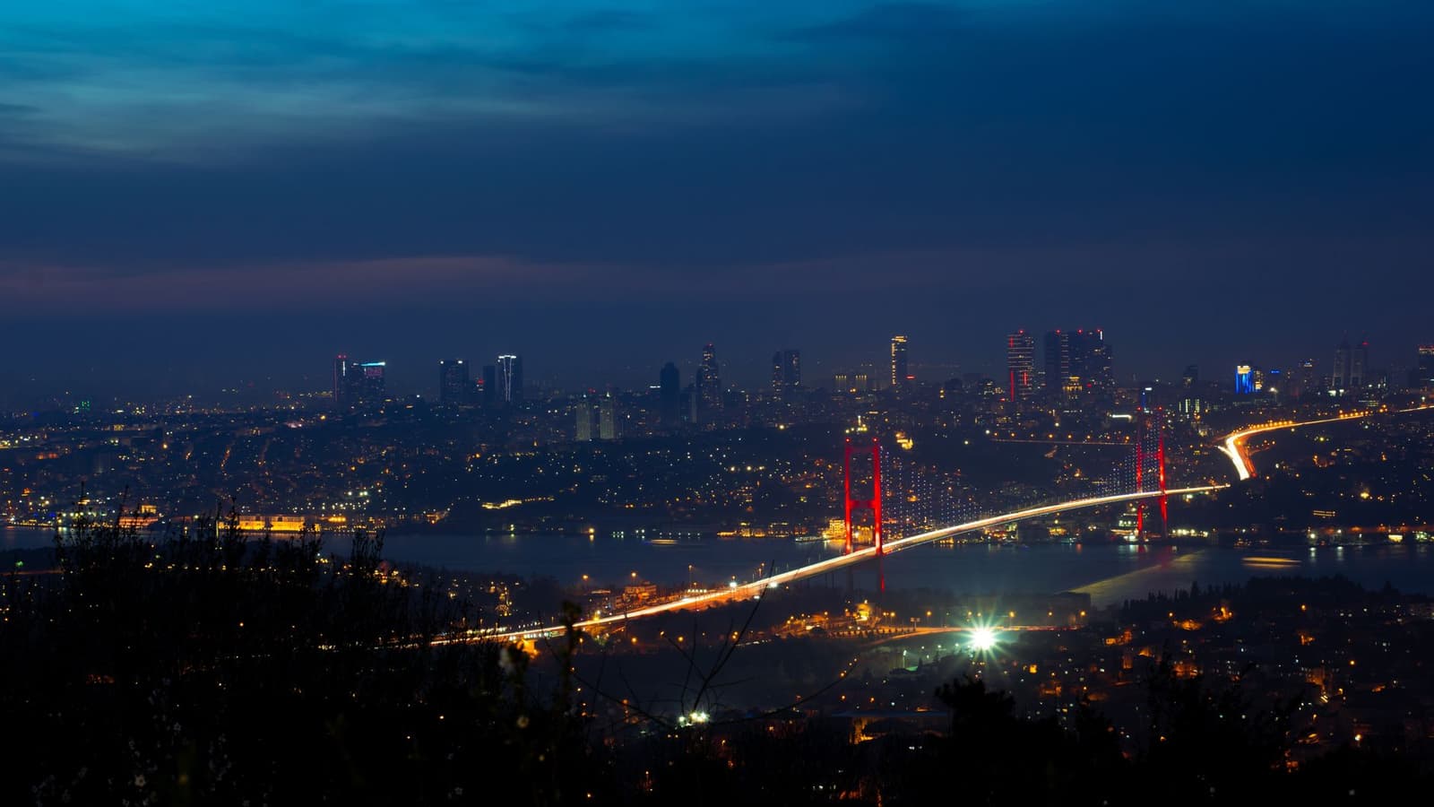 El puente del Bósforo iluminado y el perfil de Estambul de noche