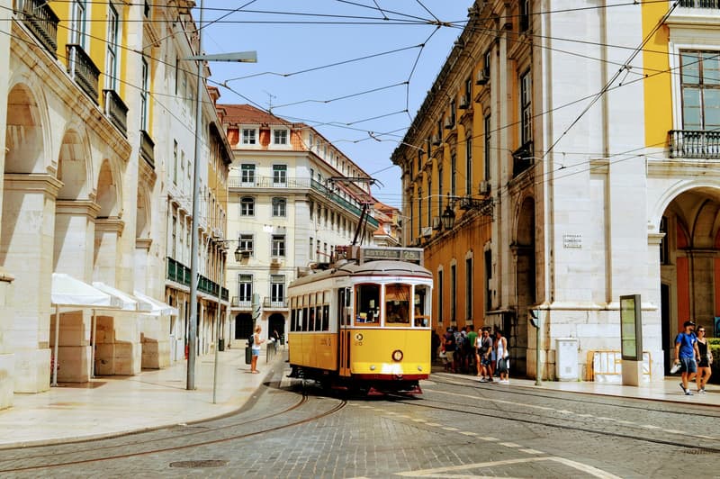 Un tramway jaune de Lisbonne traversant le quartier de la Baixa près de la Praça do Comércio