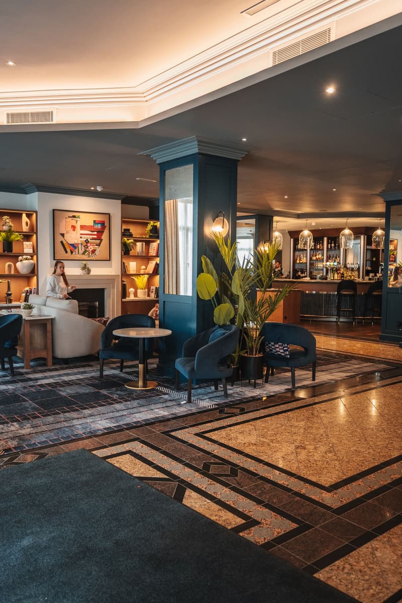 Elegante Hotellounge mit Bar, Sesseln und Marmorboden