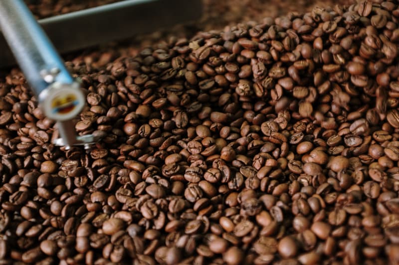 Primer plano de granos de café en un tostador profesional