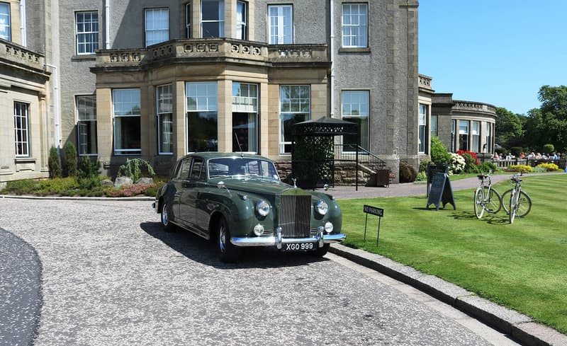 Stone frontage and gravel drive of a Scottish country hotel on a clear summer day