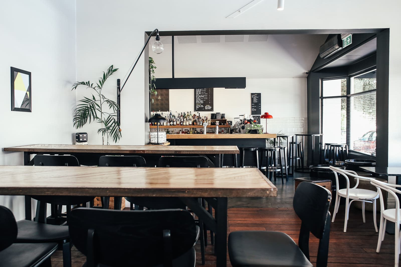Sala vuota di un pub moderno con tavoli in legno e un bancone ben fornito