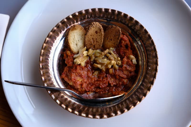 Muhammara de poivron et noix dans un bol en cuivre avec du pain grillé