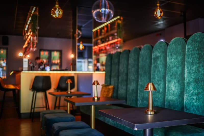 Salle de restaurant italien élégante avec murs en bois de rose et banquettes en velours