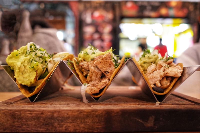 Tacos moelleux garnis de guacamole et de poulet grillé servis sur une planche en bois