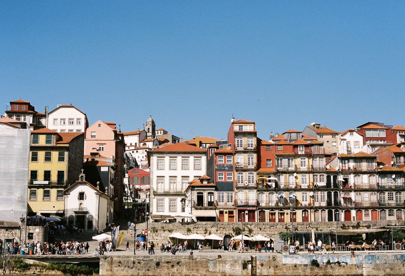 Maisons historiques colorées au bord du fleuve dans le quartier de Ribeira à Porto sous un ciel bleu