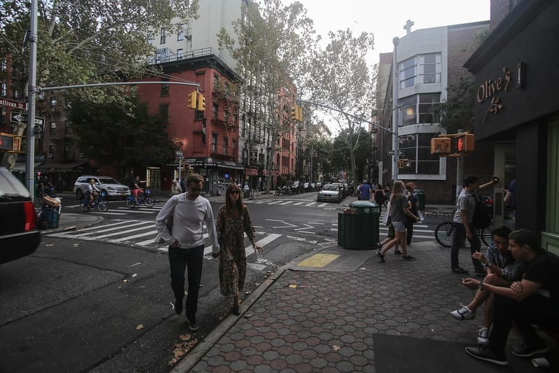 Piétons traversant Prince Street au coin de Sullivan Street à SoHo, entre immeubles de brique