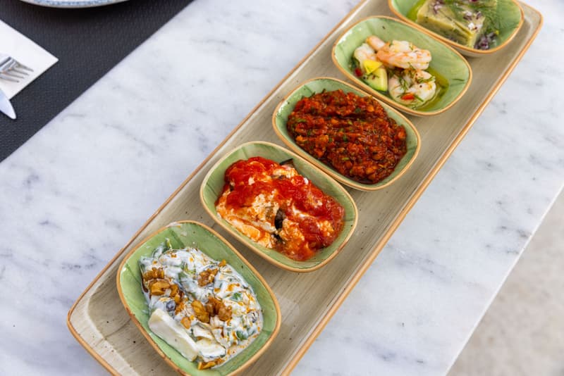 Una selezione di piccoli piatti di mezze mediterraneo su un tavolo di marmo