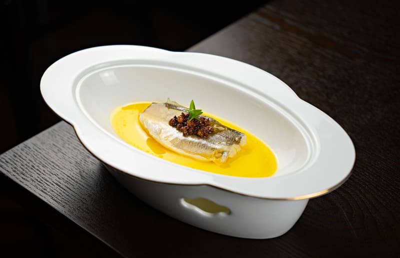 Fijn visgerecht geserveerd met citrusbotersaus in een fine dining-restaurant