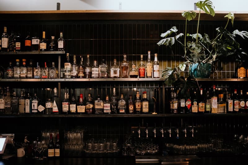 Uno scaffale da bar pieno di bottiglie di whisky, gin e liquori