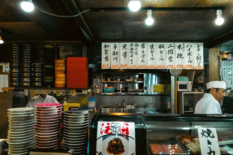 Sushichefs bereiden stukjes aan een houten sushibar