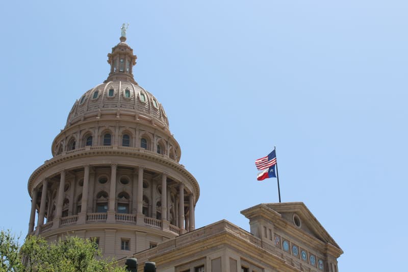 Dôme du Capitole de l'État du Texas à Austin avec les drapeaux américain et texan