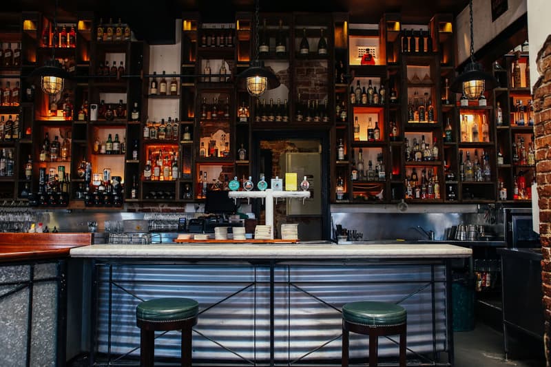 Un mur de bouteilles rétroéclairé et un comptoir en marbre dans un pub londonien moderne