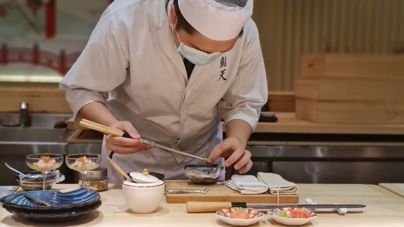 Chef sushi dressant des nigiri au comptoir d'un omakase