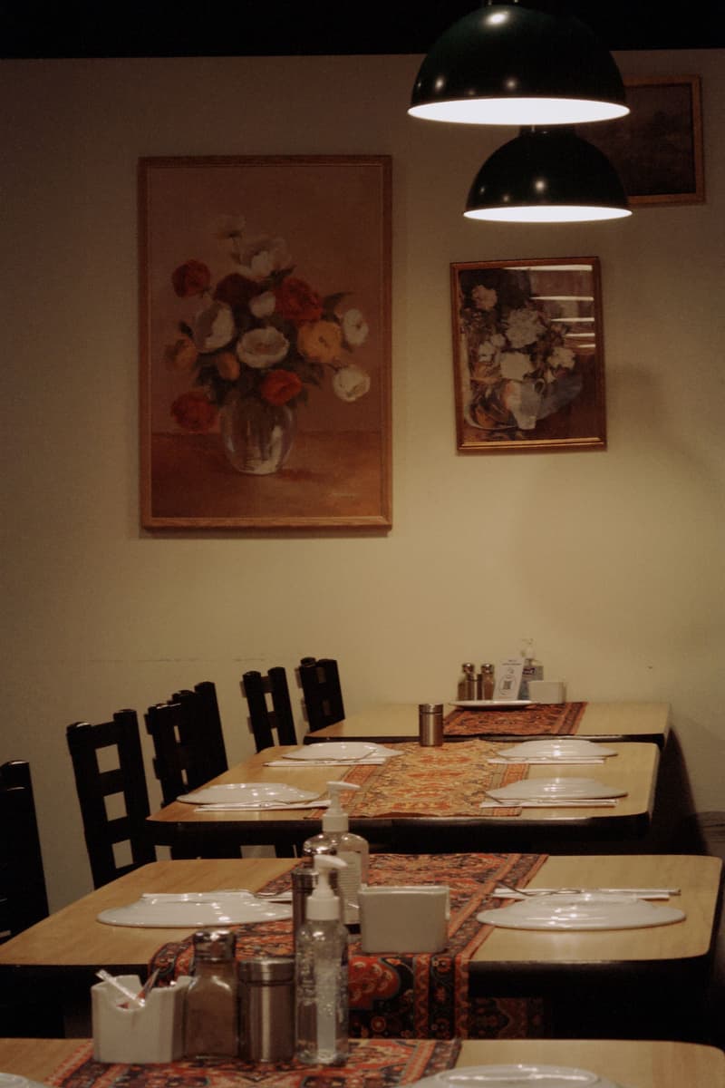 Mesas vacías ya preparadas en un comedor de restaurante en penumbra