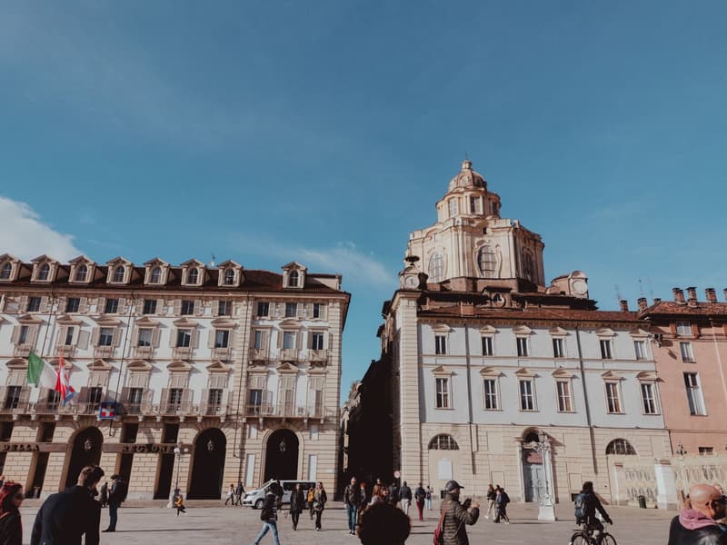 La Piazza Castello ensoleillée à Turin avec le dôme du Palazzo Madama et des passants