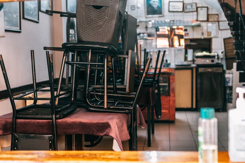 Sillas apiladas sobre una mesa con mantel en el comedor de un café cerrado