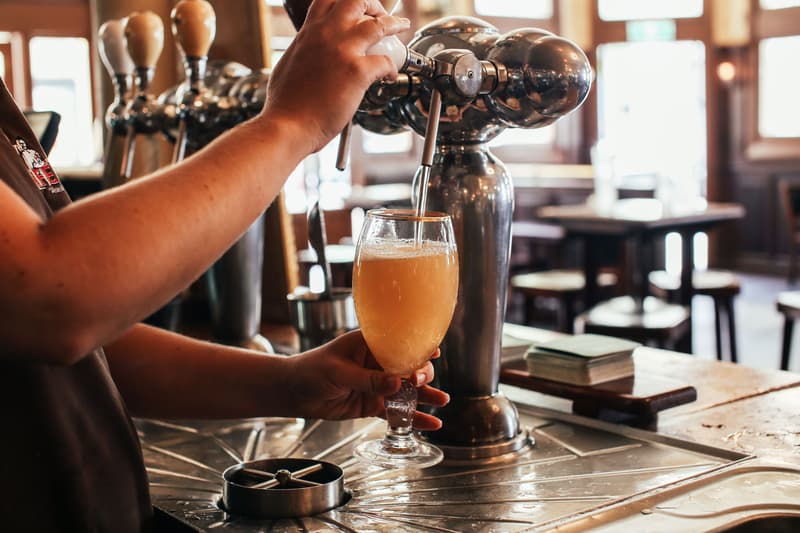 Un barman verse une pinte de bière à la pression dans un pub