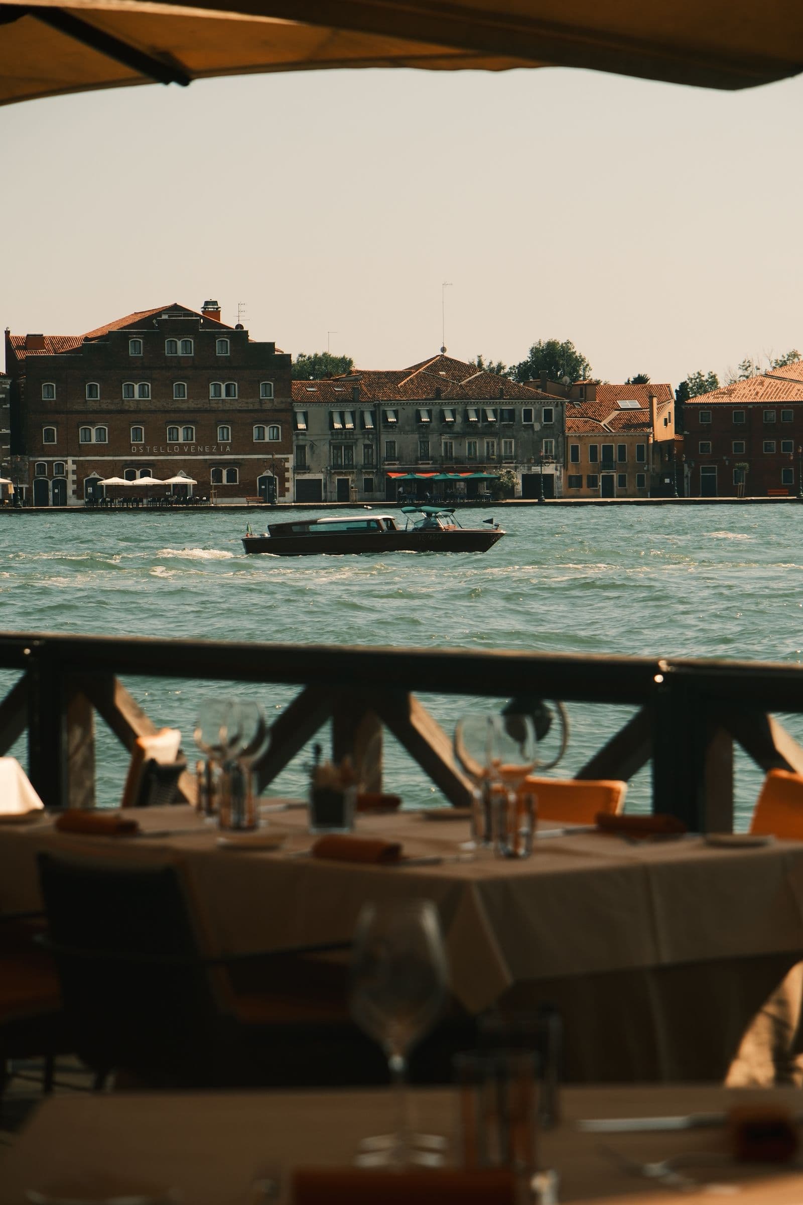 Eine Restaurantterrasse am Kanal gegenüber den Dächern von Giudecca in Venedig