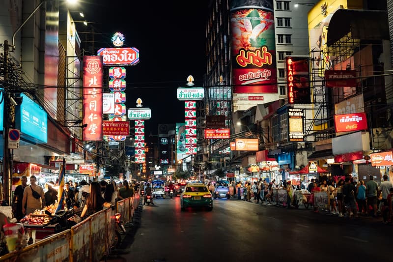 Letreros de neón y puestos de comida callejera en Yaowarat Road, el Chinatown de Bangkok, de noche