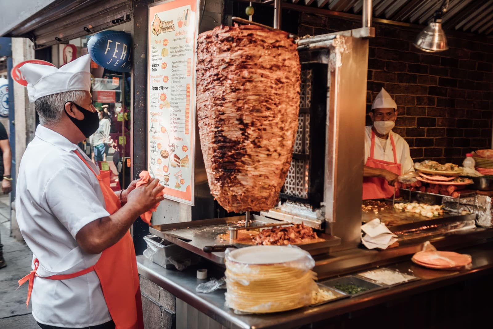 Taquero cortando carne al pastor del trompo en un puesto de tacos de Ciudad de México