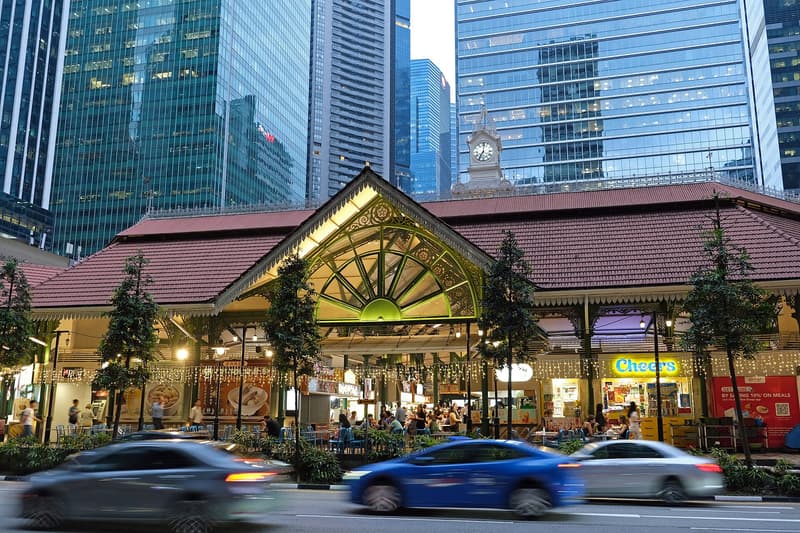 Das Hawker Centre Lau Pa Sat in der Abenddämmerung, beleuchteter viktorianischer Giebel unter Singapurs Bürotürmen