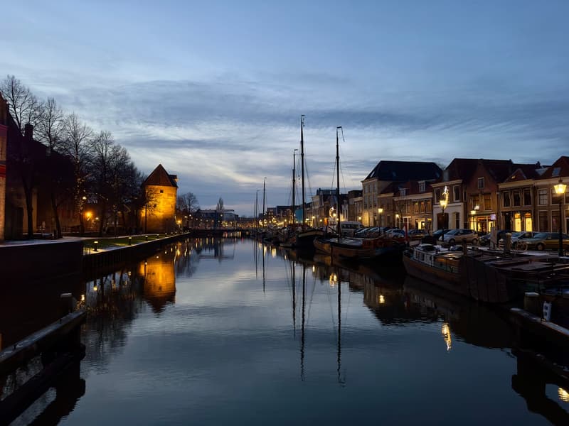 Canal historique de Zwolle au crépuscule bordé de bateaux et de maisons à pignons