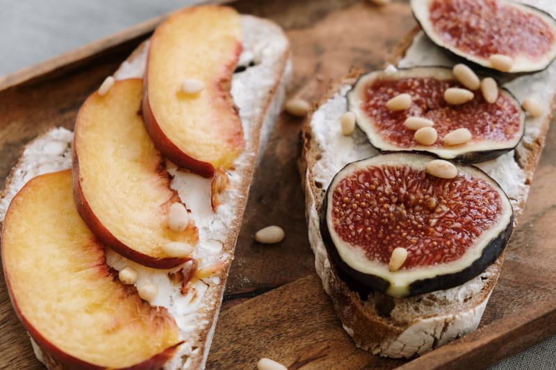 Pan tostado cubierto con ricotta batida, higos frescos y piñones